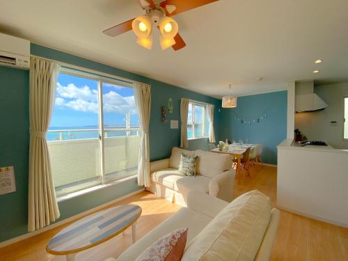 a living room with a view of the ocean at グランディオーソ沖縄ヴィラ金武1 in Okinawa City