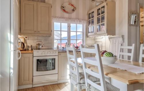 a kitchen with white cabinets and a table and chairs at Gorgeous Home In Åsa With Wifi in Åsa