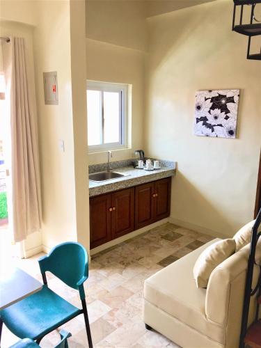 a living room with a couch and a sink at Elliannah Pines Hotel in Baguio