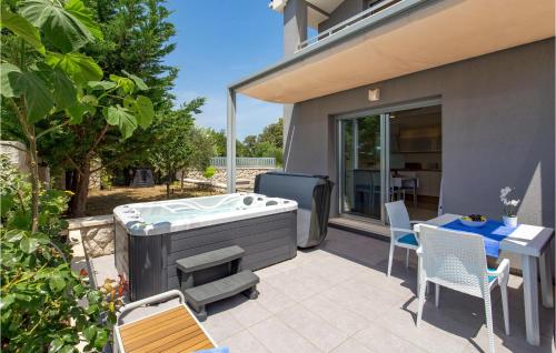 a hot tub on a patio with a table and chairs at 1 Bedroom Awesome Home In Rab in Rab