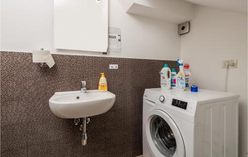 a bathroom with a washing machine and a sink at 1 Bedroom Awesome Home In Rab in Rab