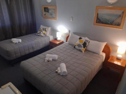 a bedroom with two beds with stuffed animals on them at Civic Motel Grafton in Grafton