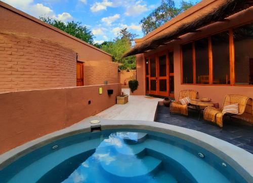 a swimming pool in front of a house at Hotel Pascual Andino in San Pedro de Atacama