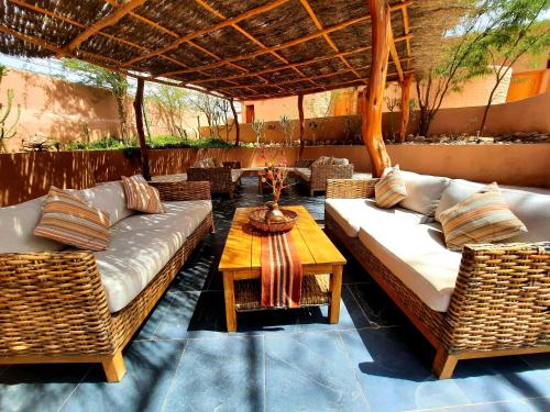 a patio with two couches and a table and chairs at Hotel Pascual Andino in San Pedro de Atacama