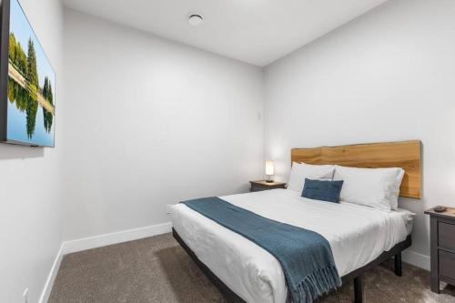 a bedroom with a large bed with a blue blanket at Beach Suites in Parksville