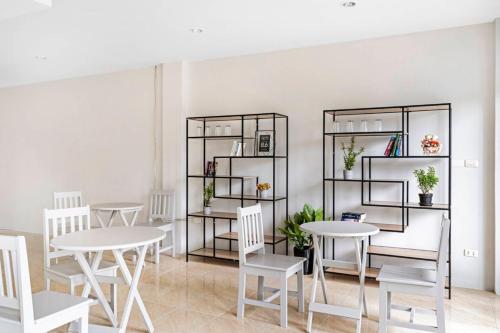 a room with white tables and white chairs and shelves at Chaweng Terrace in Chaweng