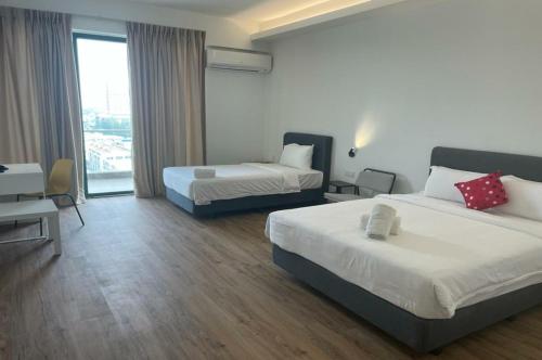 pokój hotelowy z 2 łóżkami i oknem w obiekcie Swan Garden Resort Hotel w Malakce