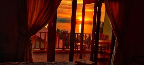 a room with a window looking out at a sunset at Free Beach Resort in Phu Quoc