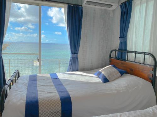 a bedroom with a bed with a view of the ocean at グランディオーソ沖縄ヴィラ金武1 in Okinawa City