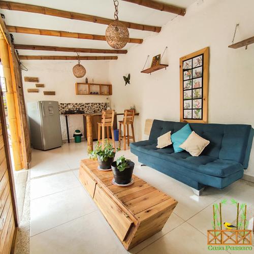 un soggiorno con divano blu e tavolo di Casa Passaro a Calarcá