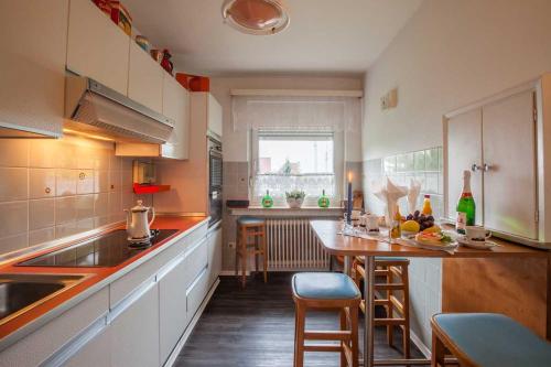 a kitchen with a table and some chairs in it at Haus Prilblume in Detern