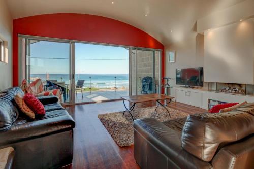 a living room with leather furniture and a view of the ocean at Malahide in Port Fairy