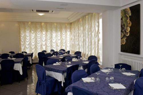 a dining room with blue tables and blue chairs at Hotel Mediterraneo in Pesaro