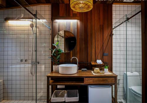 a bathroom with a sink and a shower with a mirror at Athita The Hidden Court Chiang Saen Boutique Hotel SHA Plus CERTIFIED in Chiang Rai