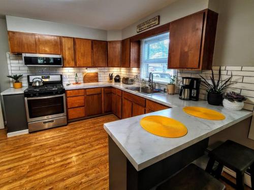 a kitchen with wooden cabinets and a counter with two plates on it at Ultra Comfy, Spotless & Spacious, Private Home in Boyne, Dogs Ok, Walk to Town in Boyne City