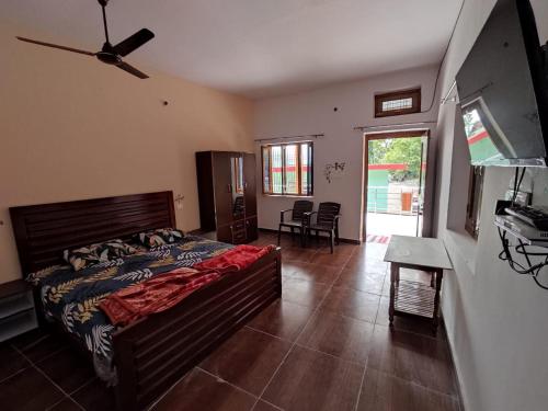 a bedroom with a bed and a room with a table at Odyssey Stays Rathuadhab (Jim Corbett National Park) in Badīyārgaon