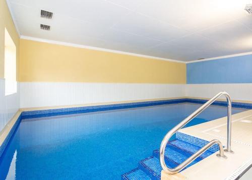 a swimming pool in a room with blue and yellow walls at Cawood Country Park in Cawood