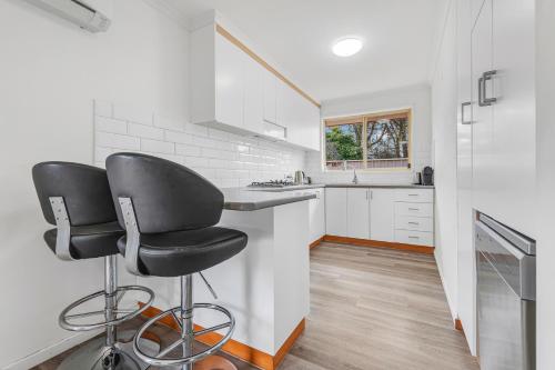 a kitchen with a black chair and a counter at Sleepy Shackell - Echuca Moama Holiday Accommodation in Echuca