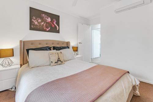 um quarto com uma cama grande num quarto branco em Sleepy Shackell - Echuca Moama Holiday Accommodation em Echuca
