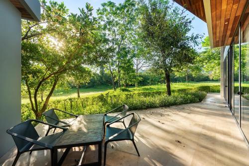 a table and chairs on a porch with a view at Gliding Villa in Khao Yai in Mu Si