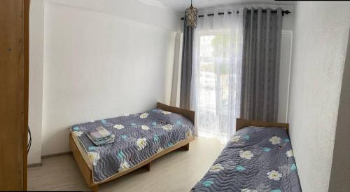 1 dormitorio con 2 camas y ventana en Apartment Paris Resort Issyk-Kul, en Chok-Tal
