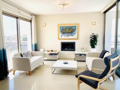 ein Wohnzimmer mit weißen Möbeln und einem TV in der Unterkunft The Penthouse 401 in Larnaka