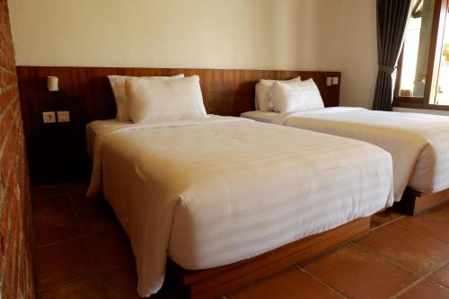 LicinにあるRumah Bata Guest Houseのベッド2台が隣同士に設置された部屋です。