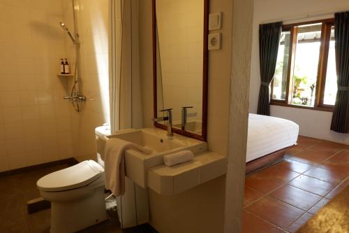 LicinにあるRumah Bata Guest Houseのバスルーム(洗面台、トイレ付)、ベッド1台が備わります。