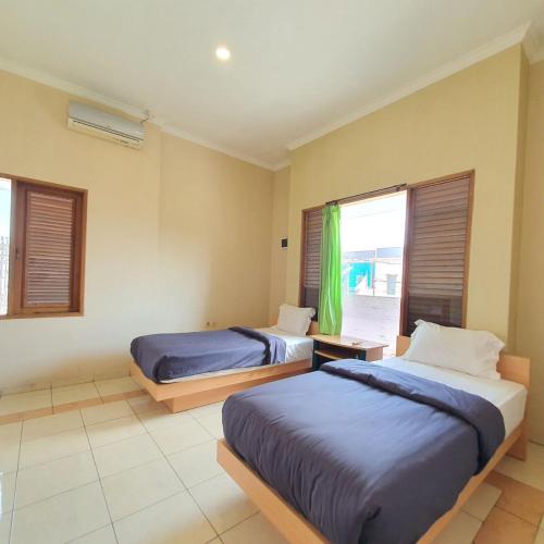 Postel nebo postele na pokoji v ubytování Candi Panggung Family Guest House Syariah