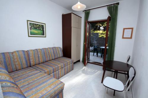 a living room with a couch and a table at Apartments by the sea Sumpetar, Omis - 4827 in Jesenice