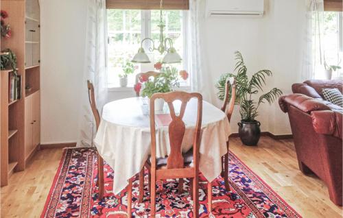 a dining room with a table and chairs on a rug at Nice Home In Halmstad With Kitchen in Öppinge