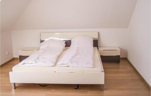 a white bed with white sheets and pillows on it at Nice Apartment In Grzybowo With Kitchenette in Grzybowo