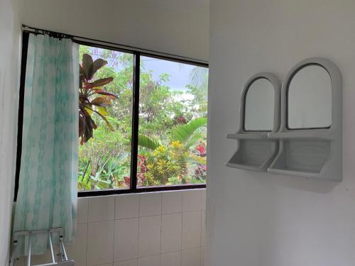 een badkamer met een raam met een douchegordijn bij Wonder-Land Villa in Ubud