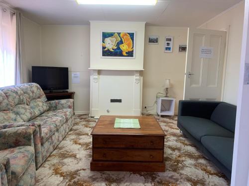 a living room with a couch and a coffee table at The Crooked Cottage in Murtoa