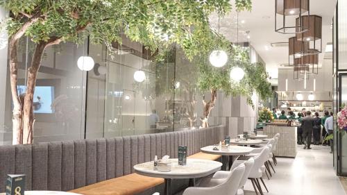 a row of tables and chairs in a restaurant at Menteng Park Exclusive Emerald in Jakarta