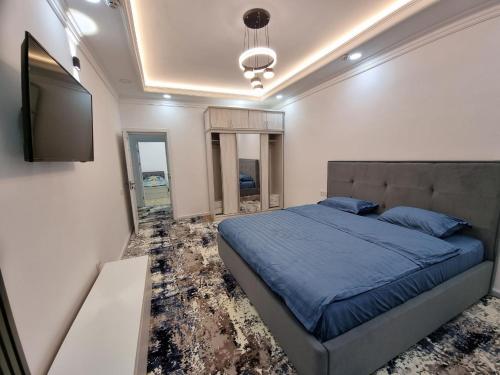 Schlafzimmer mit einem Bett und einem Flachbild-TV in der Unterkunft Квартира в аренду Tashkent in Taschkent