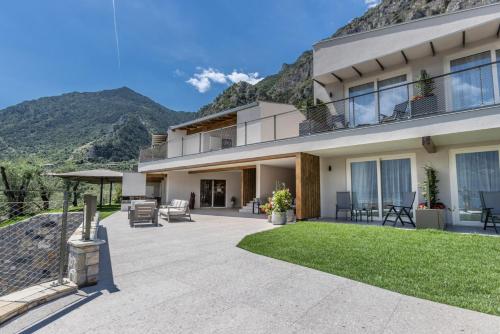 a house with a patio with mountains in the background at LLAC Living Nature Hotel in Limone sul Garda