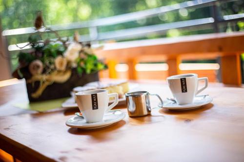 two coffee cups sitting on a wooden table at Chaty Ferrata in Martin