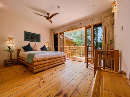 a bedroom with a bed and a balcony at Ecoboo Maldives in Thinadhoo
