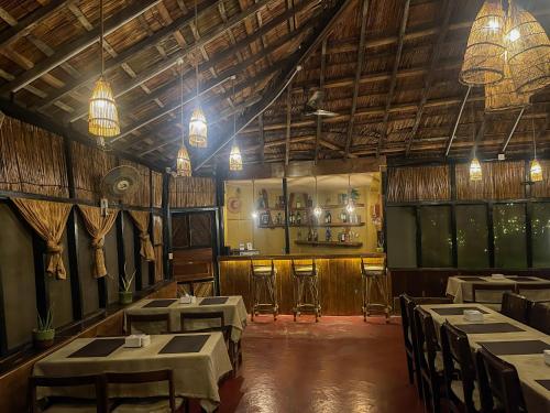 a room with tables and chairs in a restaurant at Hotel Tharu Garden, Sauraha in Sauraha