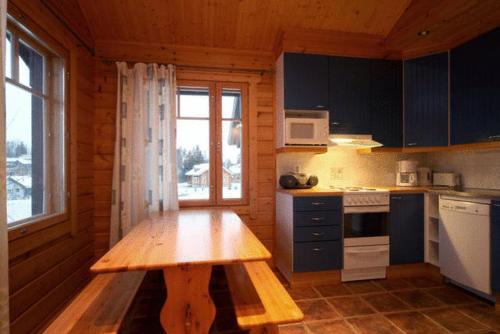 uma cozinha com uma mesa de madeira num camarote em Himoshovi Cottages em Jämsä