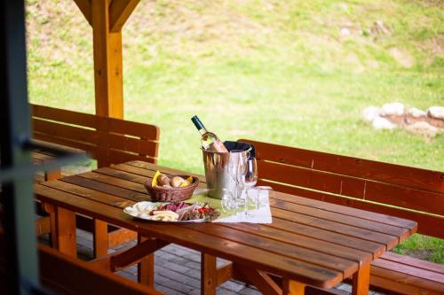 a picnic table with a bottle of wine and a basket of fruit at Chaty Ferrata in Martin