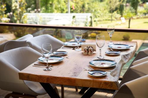 a wooden table with glasses and plates on it at Casa Giallo in Sapanca