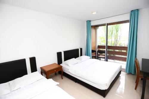 Una habitación de hotel con dos camas y balcón. en Pondok Muara Chalet, en Pantai Cenang
