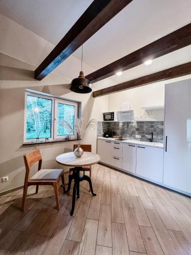 a kitchen and dining room with a table and chairs at Amber House Deluxe in Agluonėnai