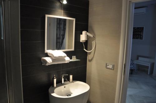 une salle de bain avec un lavabo et un miroir dans l'établissement Il Corso Suite, à Rome