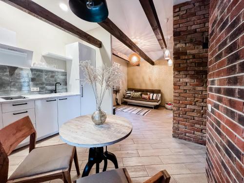 a kitchen with a table and a brick wall at Amber House Deluxe in Agluonėnai