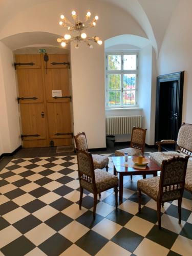 にあるZámeček Ostrovのチェッカーフロアの客室で、テーブルと椅子が備わります。
