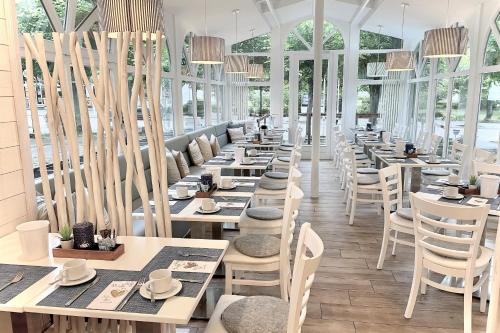 a row of tables and chairs in a restaurant at MyHome Ruegen - Haus Johanneshorst in Ostseebad Sellin