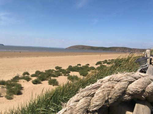 a view of a beach with a fence and grass at Ocean Drive Deluxe Apartment with complimentary Day Time Beach hut in Brean
